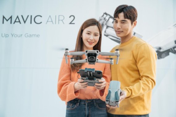 DJI 모델들이 매빅 에어2를 들고 포즈를 취하고 있다.