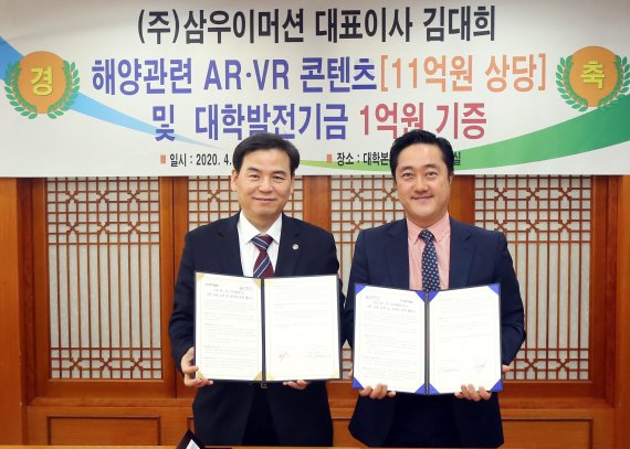 지난 28일 한국해양대 대학본부 3층에서 열린 ㈜삼우이머션이 해양 관련 AR(증강현실)·VR(가상현실) 콘텐츠와 함께 대학발전기금 1억원 기증식에서 도덕희 한국해양대 총장(왼쪽)과 김대희 삼우이머션 대표가 협약서를 들고 포즈를 취하고 있다. 사진=한국해양대 제공