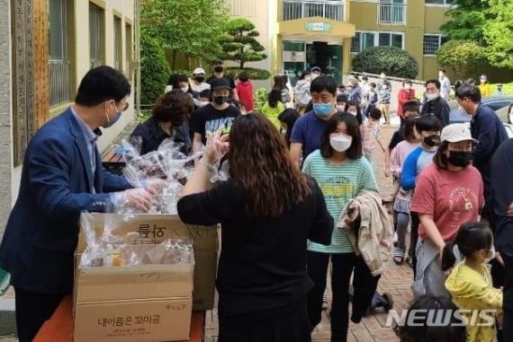 [창원=뉴시스] 경남 창원시 마산회원구 삼계대동이미지아파트대표회가 2일 오전 1단지 관리사무소 앞에서 어린이날 선물로 준비한 과자 꾸러미를 입주민 아동들에게 나눠주고 있다. (사진=이우완 페이스북 제공) 2020.05.02. photo@newsis.com