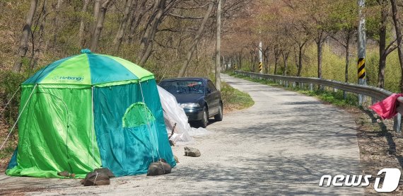 칠갑저수지와 인접한 도로에 불법낚시꾼들이 숙식을 위한 텐트를 설치하고 취사 및 야영장소로 수개월째 사용하고 있다. /© 뉴스1