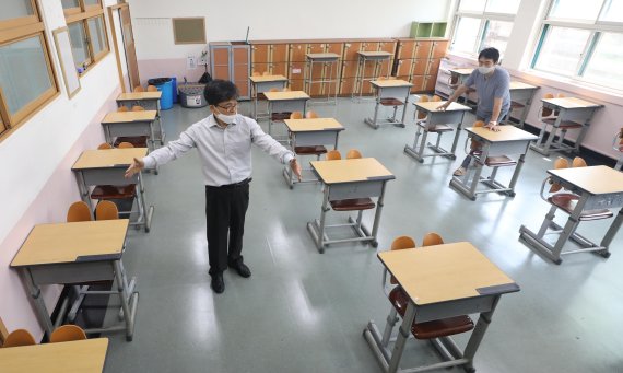 정부가 단계적인 등교 개학을 발표한 4일 서울 양천구 금옥여자고등학교에서 선생님들이 교실 책상 간격을 벌리고 있다. 뉴스1