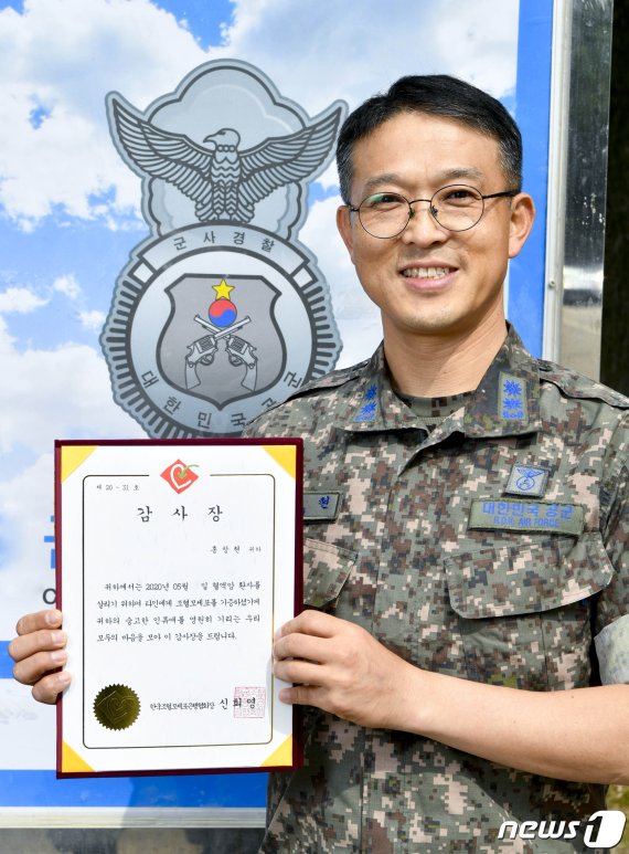 공군 군사경찰단 홍창현 중령이 한국조혈모세포은행협회로부터 받은 감사장을 들고 기념촬영을 하고 있다.(공군 제공) © 뉴스1