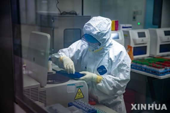 [광저우=신화/뉴시스]2월13일(현지시간) 중국 광둥성 광저우시에 있는 한 실험실에서 한 연구원이 샘플을 원심분리기에 넣고 있다. 사진=뉴시스