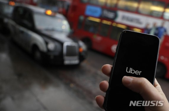 [런던=AP/뉴시스]지난해 11월25일(현지시간) 영국 런던에서 한 사용자가 차량 호출 서비스 우버 애플리케이션(앱)을 실행 중인 모습. 2020.05.19.