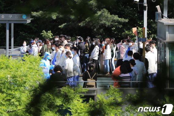 삼성서울병원에서 간호사 4명이 한꺼번에 '코로나19' 확진판정을 받으면서 의료체계에 비상이 걸린 가운데 19일 오후 서울 강남구 삼성서울병원 주차장에 마련된 선별진료소에서 의료진과 관계자들이 코로나19 검사를 위해 대기하고 있다. 뉴스1.