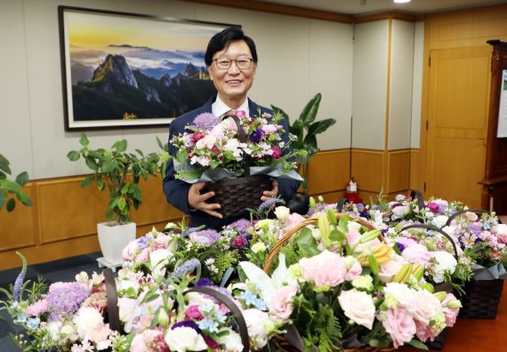 황창화 한국지역난방공사 사장이 지난 21일 화훼농가를 돕는 '플라워 버킷 챌린지' 캠페인에 동참하며 기념촬영을 하고 있다. 지역난방공사 제공