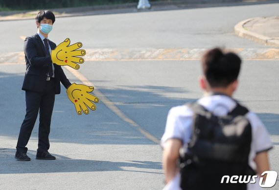 신종 코로나바이러스 감염증(코로나19) 여파로 등교가 미뤄졌던 유치원, 초·중·고교가 부분 개학한 가운데 28일 오전 대구의 한 중·고등학교 정문에서 등교지도 교사가 학생들과 인사를 나누고 있다. 사진은 기사와 직접적 연관 없음. 2020.5.28/뉴스1 © News1 공정식 기자