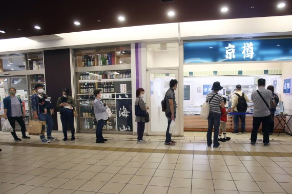 지난달 28일 요코하마의 한 스시가게 앞. 마스크를 쓴 사람들이 코로나19 감염 방지 차원에서 앞 사람과 거리를 두고 순서를 기다리고 있다. AP뉴시스