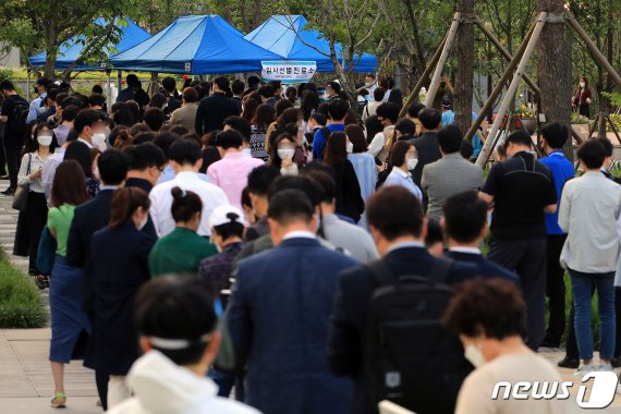 지난달 28일 서울 중구 서소문공원에 마련된 코로나19 선별진료소에서 직장인들이 검사를 위해 대기하고 있다. 뉴스1 제공