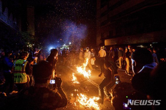 [오클랜드=AP/뉴시스] 29일(현지시간) 미국 캘리포니아주 오클랜드에서 시위대가 쓰레기를 불태우고 있다. 이날 미국 곳곳에서 비무장 흑인 조지 플로이드가 백인 경찰에게 목이 짓눌려 사망한 사건을 규탄하는 시위가 열렸다.