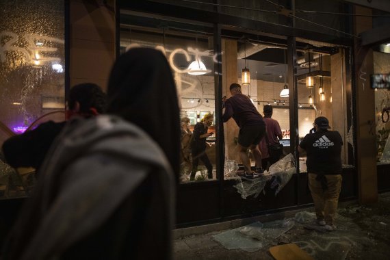 미국 캘리포나이주 로스앤젤레스에서 29일(현지시간) 조지 플로이드 사망 사건을 규탄하는 시위대가 스타벅스 매장을 파괴하고 있다.AP뉴시스