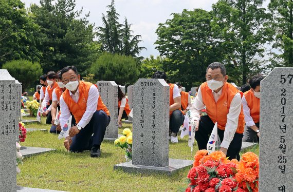 김신연 한화커뮤니케이션위원회 사장(앞줄 오른쪽 첫번째)을 비롯한 임직원들이 묘역에 놓인 태극기를 교체하고 있다. 한화 제공