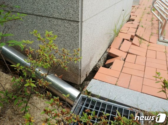 3일 오전 11시15분쯤 부산 강서구 송정동 녹산금융공단 안에 있는 2층 규모의 경남은행 녹산지점 건물과 주차장에서 지반 침하 현상이 나타나 직원들이 대피하는 소동이 벌어졌다. 땅이 꺼지면서 건물 주변에 깔린 블럭과 시설물이 파손된 모습.(부산소방재난본부 제공)© 뉴스1