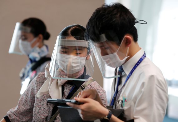 지난 4일 하네다공항에서 전일본공수(ANA)항공 직원들이 코로나19 감염을 방지하기 위해 마스크에 투명 플라스틱 안면 가리개를 쓰고 있다. 로이터 뉴스1