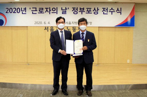 삼육대 이준태 총무인사팀장(오른쪽)이 지난 4일 '2020년 근로자의 날 유공 정부표상 전수식'에서 대통령 표창을 받고 정민오 서울지방고용노동청장과 기념촬영을 하고 있다. 삼육대학교 제공