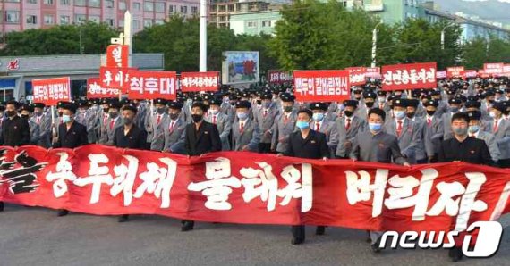 대북전단 살포에 항의하는 군중시위를 벌이는 북한 주민들이 (전단 살포를 하는) '역적무리들을 송두리째 불태워버리자'고 적힌 선전물을 들고 행진하고 있다. /사진=뉴스1