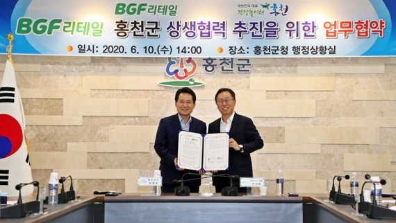 BGF리테일 이건준 대표이사(오른쪽)와 허필홍 홍천군수가 업무협약 기념촬영을 하고 있다. BGF리테일 제공.