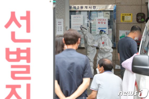 10여명의 무더기 신종 코로나바이러스 감염증(코로나19) 확진자가 도봉구 성심데이케어센터에서 발생한 가운데 12일 서울 도봉구보건소에서 시민들이 검체 검사를 받기 위해 기다리고 있다. 도봉구청 관계자는 해당 센터에 있는 어르신들 40여 명과 직원 23명 등 모두 60여 명에 대한 전수검사를 진행해 확진자 14명을 파악했다고 밝혔다./뉴스1 © News1 이성철 기자
