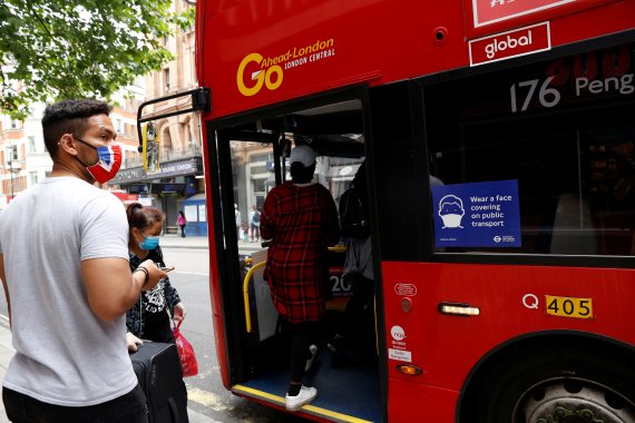지난 6월15일(현지시간) 영국 런던 레스터 광장 부근에서 마스크를 착용한 시민들이 버스에 탑승하고 있다.로이터뉴스1