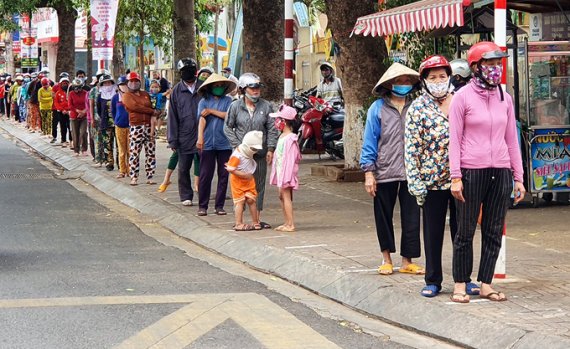 무료 쌀 ATM에서 쌀 배급을 받기 위해 줄 서있는 베트남 사람들. VN익스프레스