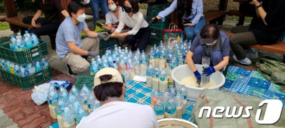 탈북자 단체인 큰샘 관계자들이 18일 서울 강남구 수서동의 한 공원에서 북으로 보낼 쌀을 페트병에 담고 있다.(큰샘제공) 2020.6.18/뉴스1 © News1 정진욱 기자