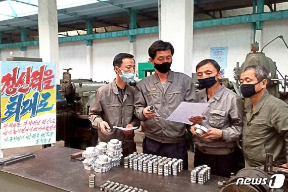 (평양 노동신문=뉴스1) = 북한 노동당 기관지 노동신문이 5월29일 보도한 평양 자동화 기구공장 일꾼들. '정신력을 최대로'라고 적힌 선전물이 보인다. [국내에서만 사용가능. 재배포 금지. DB 금지. For Use Only in the Republic of Korea. Redistribution Prohibited] rodongphoto@news1.kr