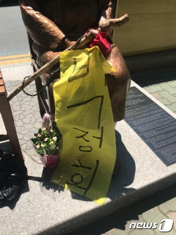 부산 동구 일본총영사관 앞에 건립된 평화의 소녀상 옆에 '박정희' 라고 적힌 천과 지팡이 형태의 나무 막대기가 놓여져 있다.(소녀상을 지키는 부산 시민행동 제공)© 뉴스1