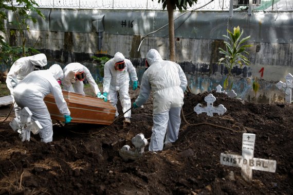 24일(현지시간) 중미 엘살바도르의 산타￼테클라에서 공동묘지 직원들이 코로나19로 숨진 환자를 매장하고 있다.로이터뉴스1