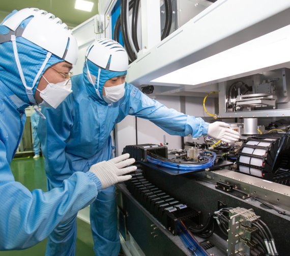 삼성전자 직원이 레이저 설비 협력사인 이오테크닉스 직원과 양사가 공동 개발한 반도체 레이저 설비를 살펴보고 있다. 삼성전자 제공