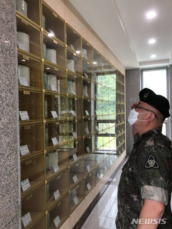 [임실=뉴시스]윤난슬 기자 = 6·25 참전용사인 임종각씨와 아내 김순녀씨의 임실호국원 합동안장 이후 유골함 앞에서 경례하는 이인호 상사 모습.(사진=육군 35사단 제공)