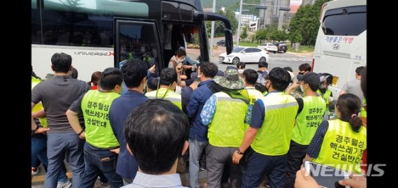 [경주=뉴시스] 이은희 기자= 27일 하이코 앞에서 버스에 탄 시민참여단이 사전워크숍에 참석하기 위해 내리자 이를 막으려는 반대 대책위 주민들과 말리는 경찰이 몸싸움을 벌이고 있다. 2020.6.29.leh@newsis.com