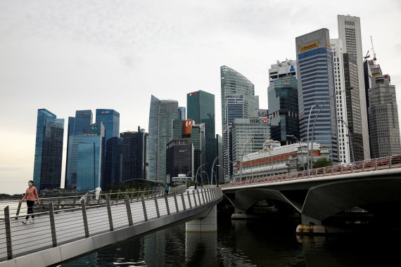 지난 5월27일 마스크를 쓴 여성이 싱가포르 금융가 앞 해안을 걷고있다.로이터뉴스1