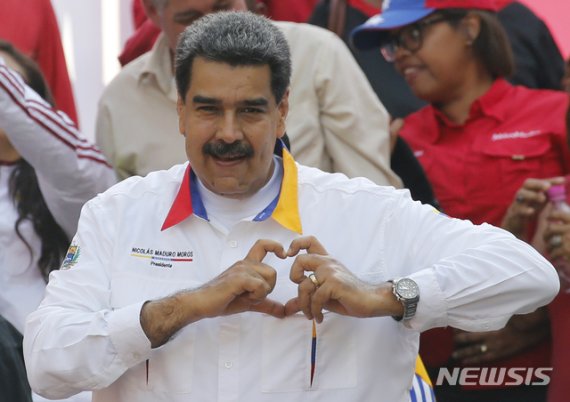 【카라카스=AP/뉴시스】 니콜라스 마두로 베네수엘라 대통령이 2019년 5월20일 대통령궁 앞에서 지지자들에게 손가락으로 하트를 그려 보이고 있다. 2019.05.27.