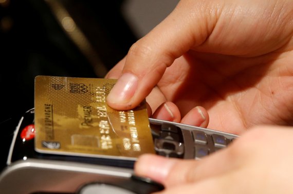 프랑스 파리의 한 상점에서 2016년 4월 11일(현지시간) 한 고객이 신용카드로 결제하고 있다. MIT 연구진은 13일 신용카드로 결제를 하면 뇌의 보상체계가 활성화돼 추가 지출 가능성을 높인다고 밝혔다. 사진=로이터뉴스1
