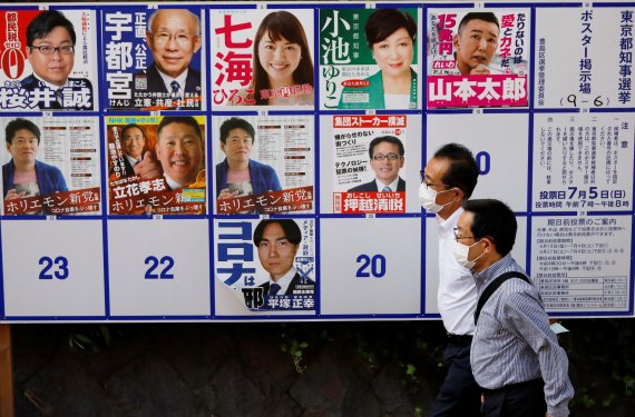 2일 마스크를 쓴 행인들이 도쿄도지사 선거(7월 5일) 후보자 포스터판 앞을 지나고 있다. 로이터 뉴스1