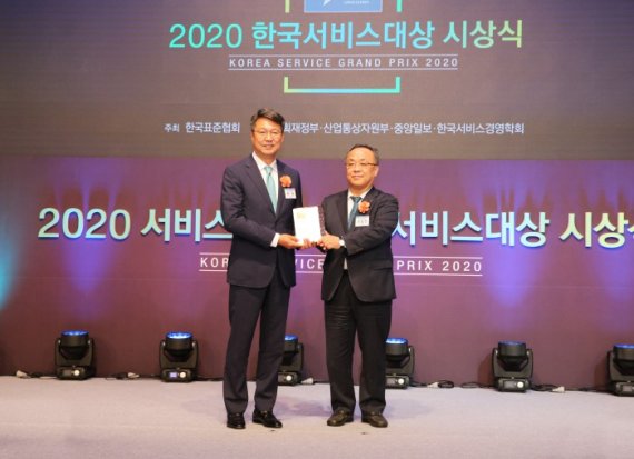 백현 롯데관광개발 대표이사(왼쪽)가 한국표준협회 이상진 회장으로부터 2020 한국서비스대상 여행서비스 부문 종합대상을 수상했다. [사진=롯데관광개발 제공]