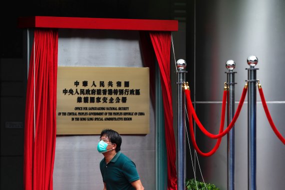 8일 홍콩 코즈웨이베이 메트로파크 호텔에서 한 노동자가 임시 개관한 '국가안전공서' 현판 앞을 지나고 있다. 국가안전공서는 홍콩 보안법 실행을 위해 중국 정부가 설치한 관리부서로 이날부터 업무를 시작했다.로이터뉴스1