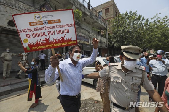 [뉴델리= AP/뉴시스]지난 6월 22일(현지시간) 인도 뉴델리에서 경찰이 중국산 물품 화형식을 하던 인도 상인을 저지하고 있다. /사진=뉴시스