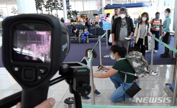 [인천공항=뉴시스] 고범준 기자 = 신종 코로나바이러스 감염증(코로나19) 확산을 막기 위해 국내·국제선 항공기 탑승객들의 마스크 착용 의무화 조치가 적용된 27일 인천국제공항 제2터미널 출국장에서 런던으로 출발하는 승객들이 체온 측정을 하며 탑승수속을 밟고 있다. 2020.05.27. bjko@newsis.com /사진=뉴시스