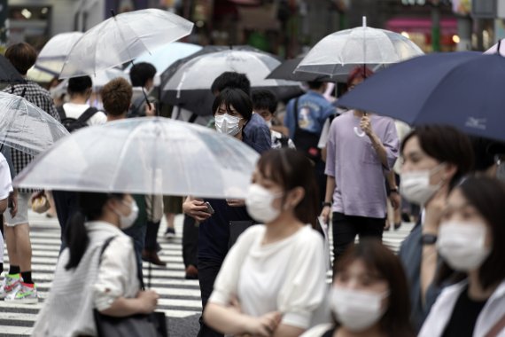 9일 도쿄의 한 횡단보도. 보행자들이 마스크를 쓴 채 길을 걷고 있다. AP뉴시스