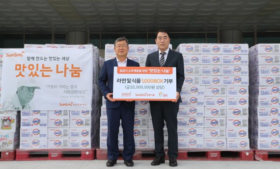 삼양식품 진종기 대표이사(오른쪽)가 박일호 밀양시장에게 후원물품을 전달하고 있다. 삼양식품 제공