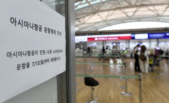 아시아나항공이 인천~중국 난징 노선 운항을 재개한 12일 인천국제공항 1터미널 출국장 아시아나 카운터에 운항 재개 안내문이 붙어 있다. 코로나19 여파로 운항을 중단한지 105일 만이다. 사진=박범준 기자
