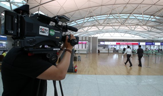 아시아나항공이 인천~중국 난징(南京) 노선 운항을 재개한 12일 오후 인천국제공항 제1터미널 아시아나항공 수속 카운터에서 중국 국영 방송사 CCTV 기자가 촬영하고 있다. 사진=박범준 기자