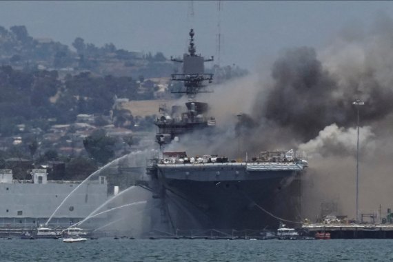 미국 캘리포니아주 샌디에이고에서 12일(현지시간) 소방 함정들이 USS 본홈 리처드(LHD-6)에 붙은 불을 끄고 있다.로이터뉴스1