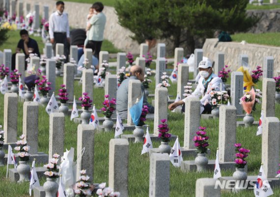 [서울=뉴시스]김명원 기자 = 제65회 현충일인 6일 오전 서울 동작구 국립서울현충원에서 유가족들이 고인의 넋을 위로하고 있다. 2020.06.06. kmx1105@newsis.com