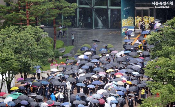 고인이 된 박원순 서울특별시장의 영결식이 13일 서울시청에서 진행됐다. 장맛비가 내리는 가운데 고인의 영정과 위패가 추모공원으로 향하고 있다. 영결식장에는 코로나19 확산 방지를 위해 유족과 시민사회 대표 등 100여명의 인원만 참석했다. 사진=김범석 기자