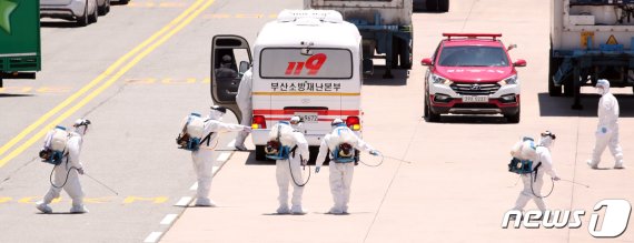 지난달 23일 오후 부산 감천항에 정박한 러시아 국적 냉동화물선에서 코로나19 양성 판정을 받은 선원들이 부산의료원 이송을 위해 부산재난본부 차량에 탑승을 마치자 방역을 진행하고 있다. 이 화물선 선원 21명 중 16명이 코로나19 양성판정을 받았다. 2020.6.23/뉴스1 © News1 여주연 기자