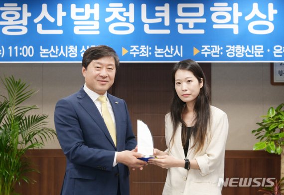 [논산=뉴시스] 이서수(오른쪽) 씨가 15일 논산시청 상황실에서 황명선 시장으로부터 제6회 황산벌청년문학상을 받고 있다.