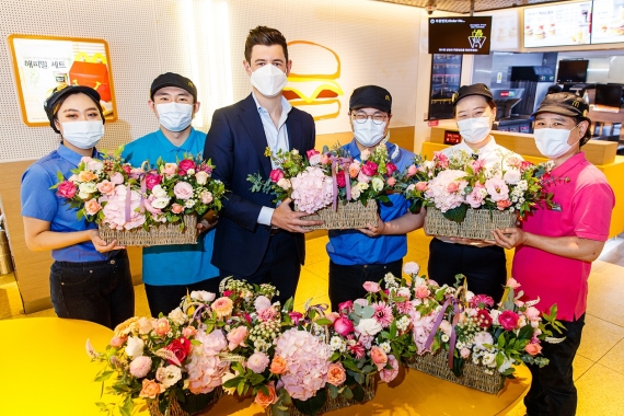맥도날드 앤토니 마티네즈 대표(왼쪽 세번째)가 지난 15일 서울 강남삼성DT점에서 박훈렬 팀 리더(왼쪽 네번째)에게 꽃바구니를 전달하며 직원들과 기념촬영을 하고 있다.