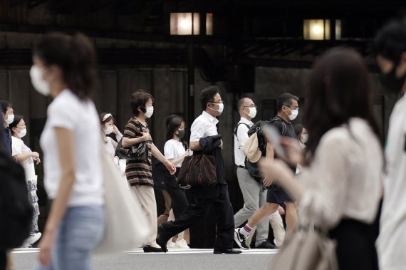 16일 코로나19 신규 확진자가 사상 최대치를 기록한 도쿄 중심가 거리 풍경. 마스크를 쓴 행인들이 길을 건너고 있다. AP뉴시스
